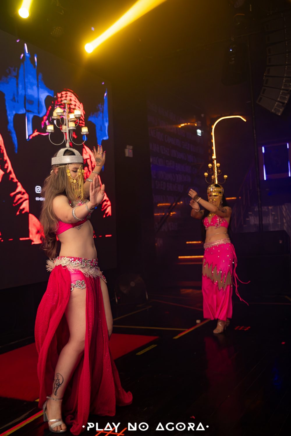 Dançarinas com candelabros na cabeça no palco